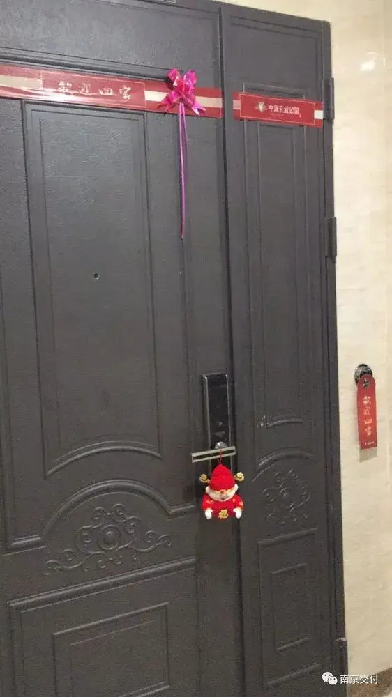 入户门上挂着财神公仔,寓意开门见财.